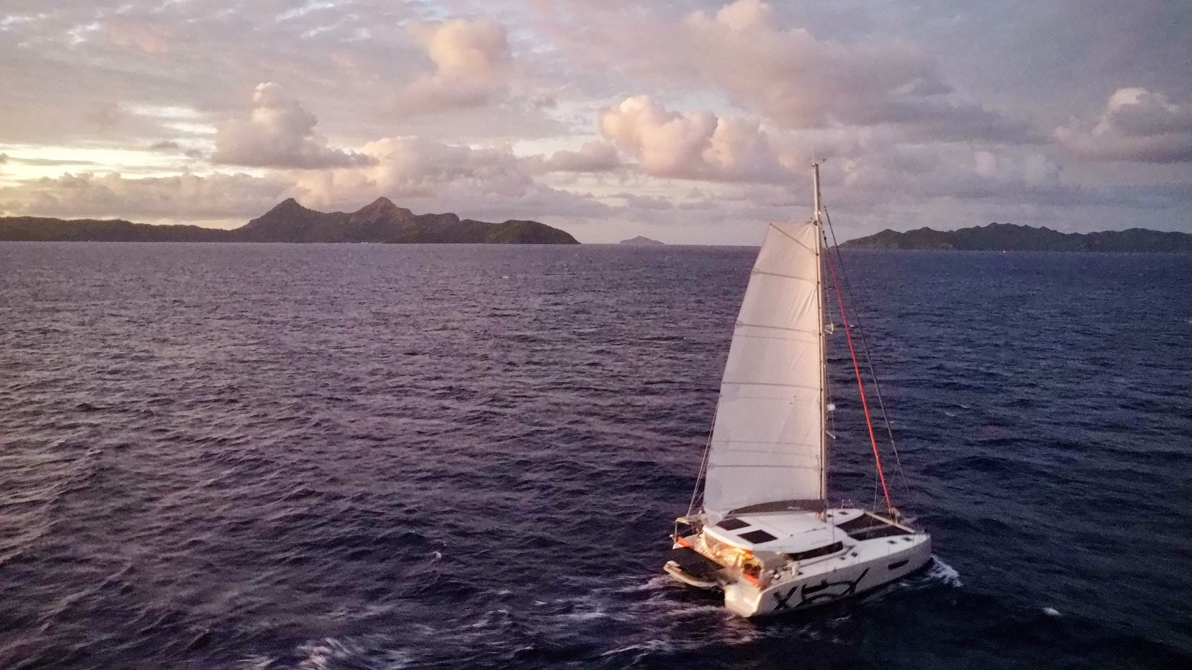 Voilier naviguant au coucher du soleil, océan Pacifique